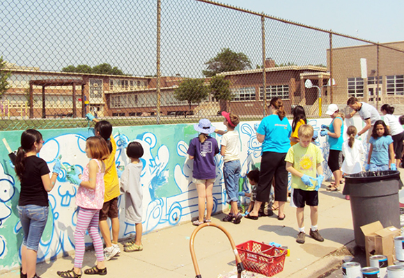 Students and parents connect on a Saturday with artist Ratha Sok and paint Brown’s final white wall, funded by Denver’s Urban Arts Fund.